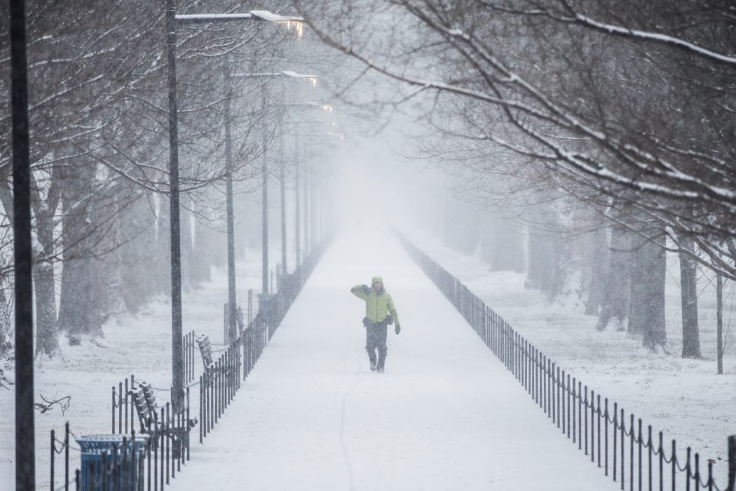 A man walks along the National Mall as the snow begins to fall in Washington, United States.