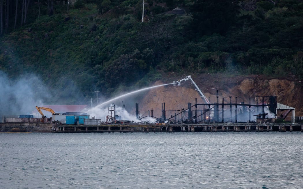 Fire crews dampen down the site of a blaze in a warehouse at Shelly Bay, Wellington.