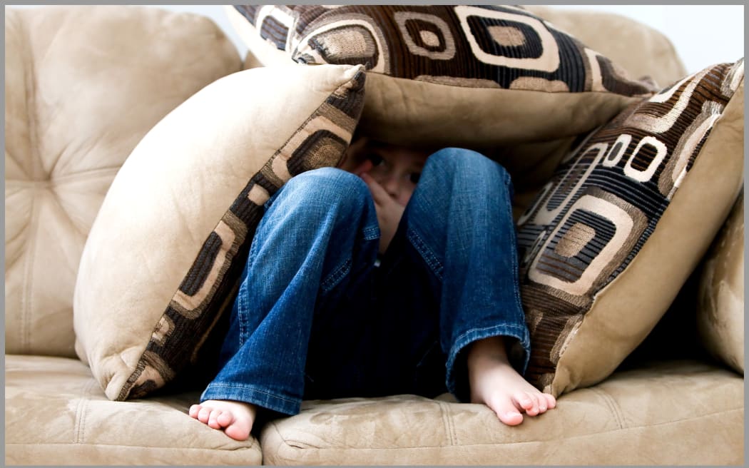 Child hiding in pillows