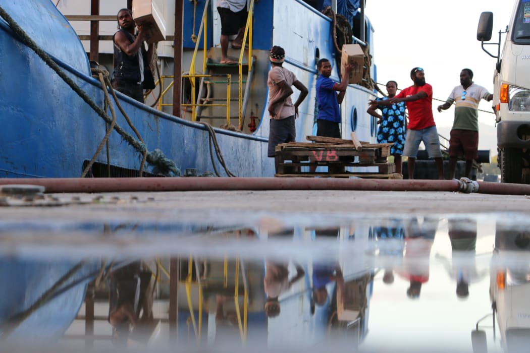 Vanuatu disaster management staff loading donated goods onto a ship heading to Ambae to help with evacuations.