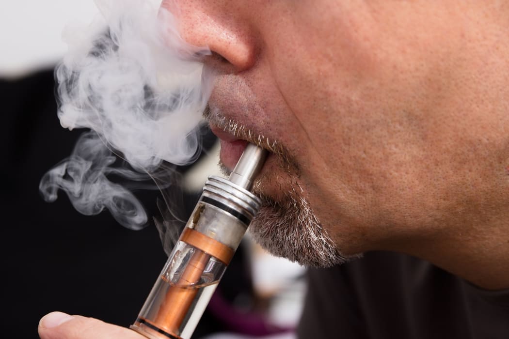 A man smokes using an e-cigarette, known as vaping (file photo)