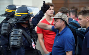 A football fan argues with riot police officers in central Lille.