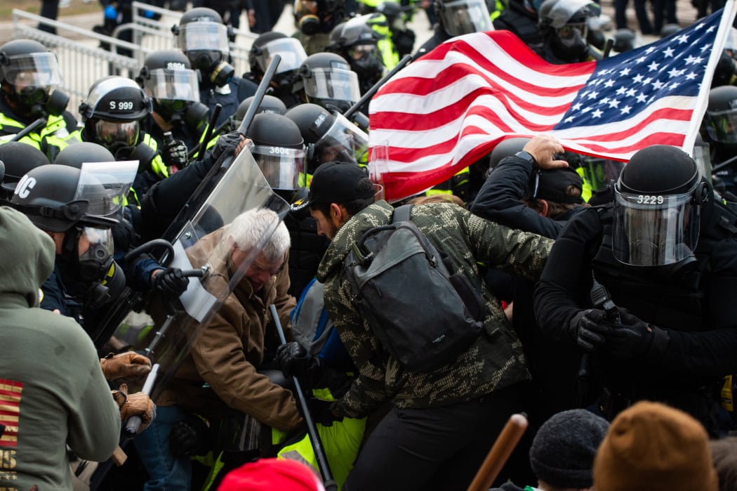 Supporters of US President Donald Trump fight with riot police outside the Capitol building on 6 January 2021 in Washington DC.