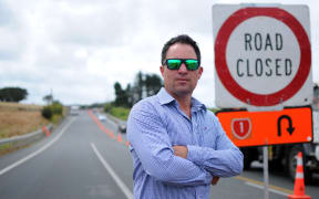 Scott McMahon in February standing on SH22 after at least three serious accidents on road diversions in the area following the start of work on the Waka Kotahi NZ Transport Agency project.