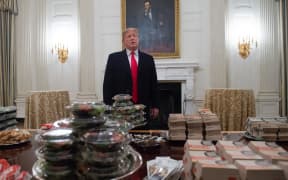 US President Donald Trump speaks alongside fast food he purchased for a ceremony honoring the 2018 College Football Playoff National Champions.