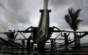 Fishermen carry an outrigger to higher ground in Legazpi City, south of Manila, on 5 December 2014, ahead of the landfall of Typhoon Hagupit.