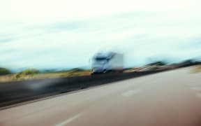 Conceptual silhouette of a defocused truck in motion on highway - pov of driver under alcohol or narcotic substance