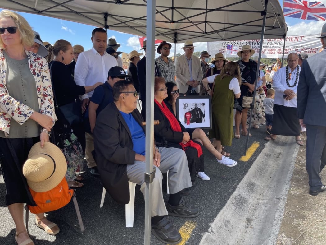 Whānau of Rudy Taylor hold a photo of the late Ngāpuhi leader as they wait to be welcomed on to Te Tii marae.