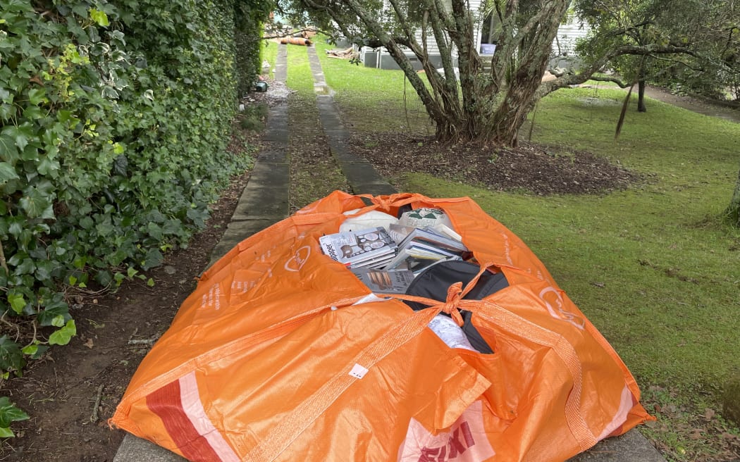 Large rubbish bags filled with books, photo albums and electrical appliances - all drenched in contaminated water - lined Tawariki Street after Auckland's flooding.