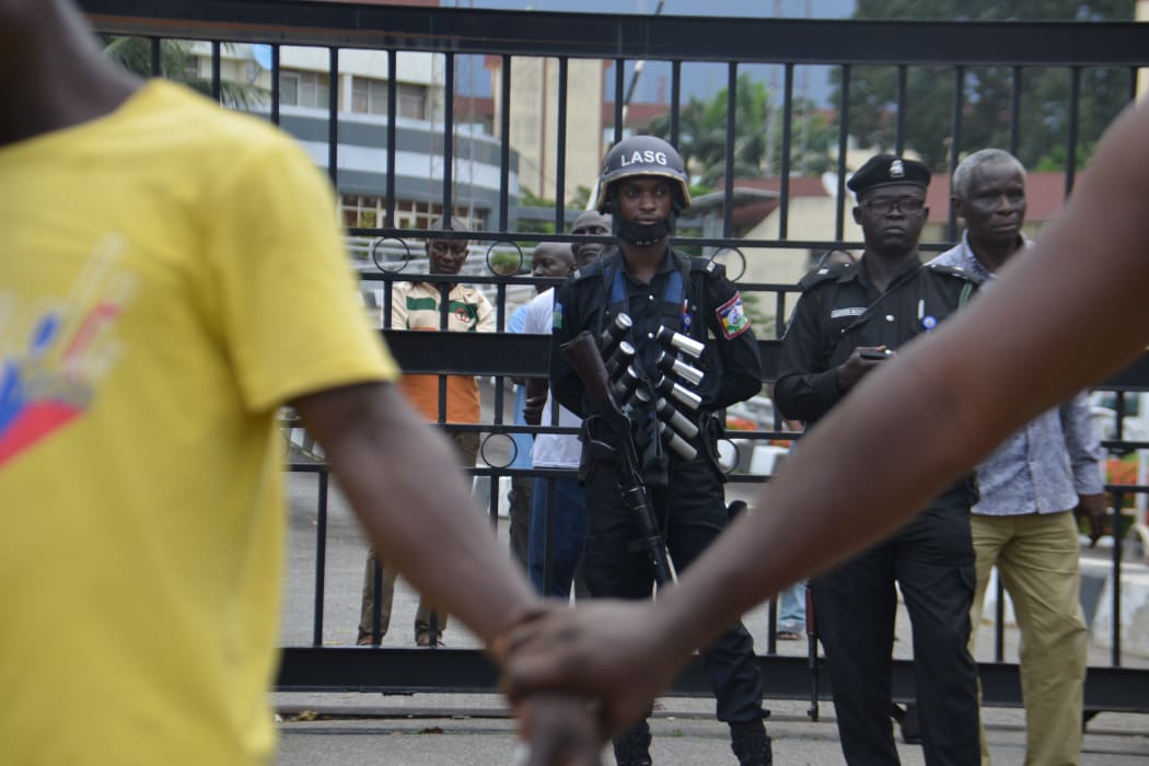 People hold hands to barricade the protesters from the Nigerian Police force as they march at Alausa Secretariat in Ikeja, Lagos State.