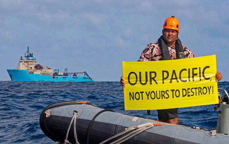 Victor Pickering, a Greenpeace activist from Fiji, in front of the Maersk Launcher, a ship chartered by DeepGreen.