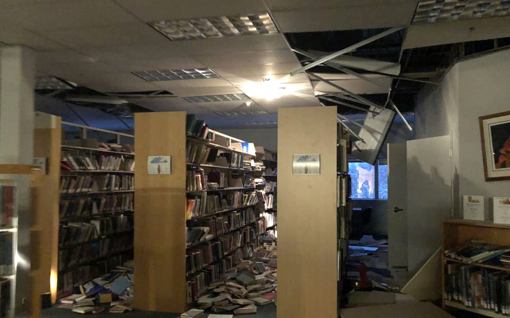 In this image courtesy of Dr Holy A Bell, books and ceiling tiles litter the floor at the Mat-Su College library in Anchorage, Alaska.