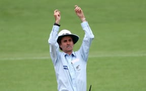 New Zealand cricket umpire Billy Bowden signals a six.