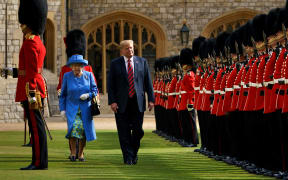 US President Donald Trump is accompanied by Britain's Queen Elizabeth II as he inspects the Guard of Honour at Windsor Castle in Windsor, west of London, on the second day of Trump's UK visit.