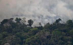 Aerial picture showing smoke from a 2km stretch of fire billowing from the Amazon rainforest, about 65 km from Porto Velho, in northern Brazil, on August 23, 2019.
