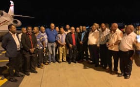 Papua New Guinea prime minister Peter O'Neill (centre, red shirt) surrounded by MPs afer arriving at Port Moresby's Jackson's Airport.