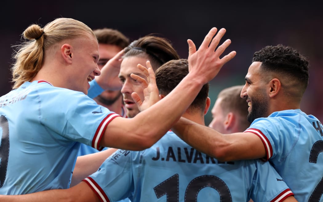 Erling Haland celebrates with Manchester City teammates.