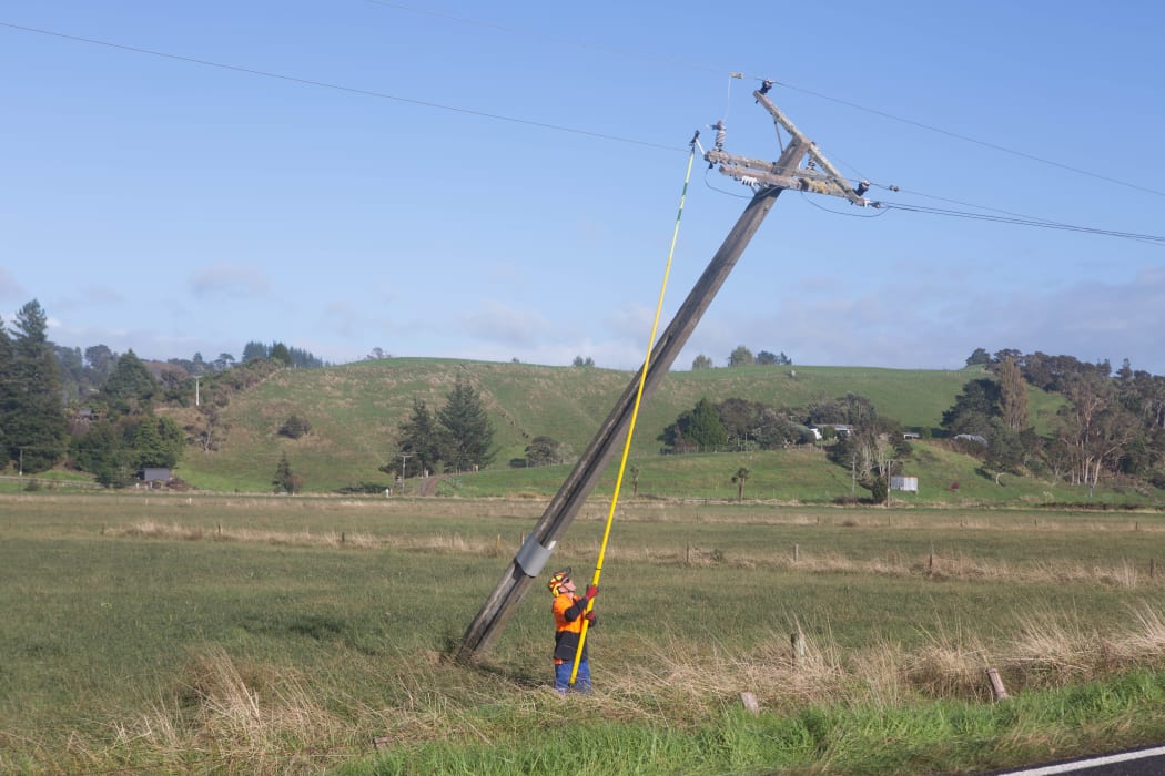 Lines workers right power poles on Wainui Road in Cheddar Valley.