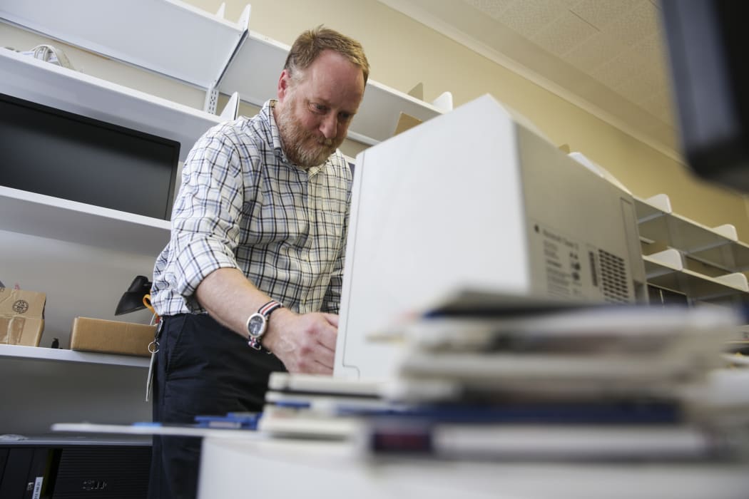 Mick Crouch works with an old-technology floppy disk reader as he preserves New Zealand’s archives