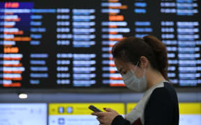 A Chinese tourist wearing a protective mask waits at Sheremetyevo airport, outside Moscow, Russia.