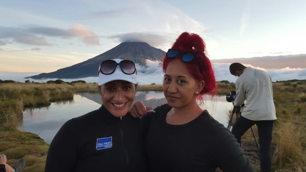 Ema Jensen and Jenna O'Brien - with Mt Taranaki in the background - on the Pouakai Crossing.