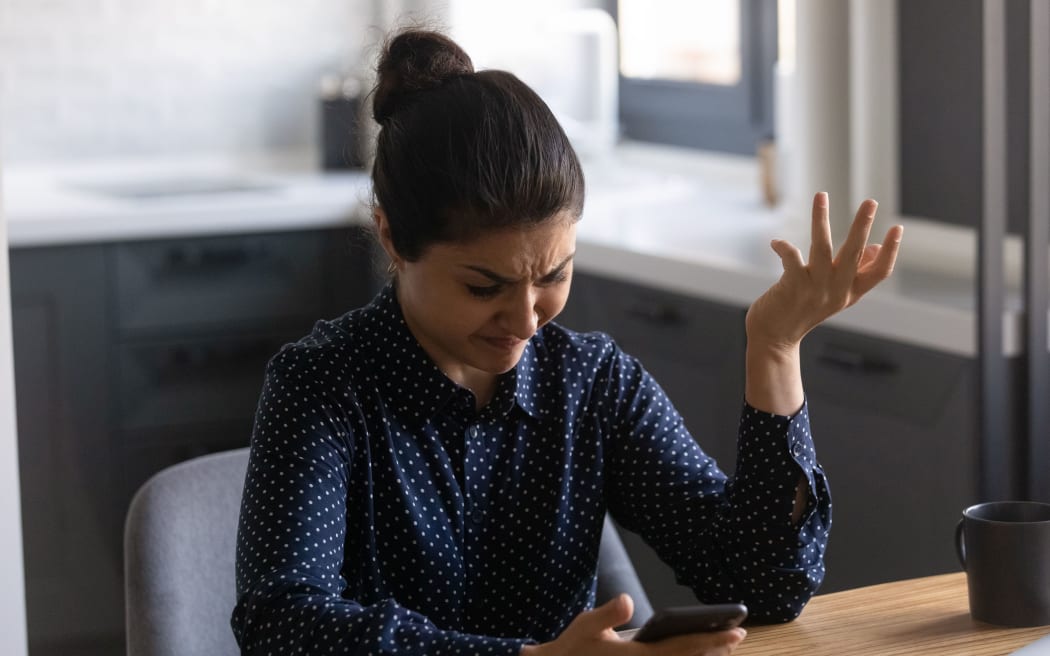 Mobile phone customers are disgusted by app performance, angry at low or lost signal, bad connection, app error.  Indian black woman feeling stressed and worried about smartphone issues