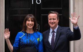 David Cameron and his wife Samantha pose for pictures as they arrive back at 10 Downing Street in London on 8 May.