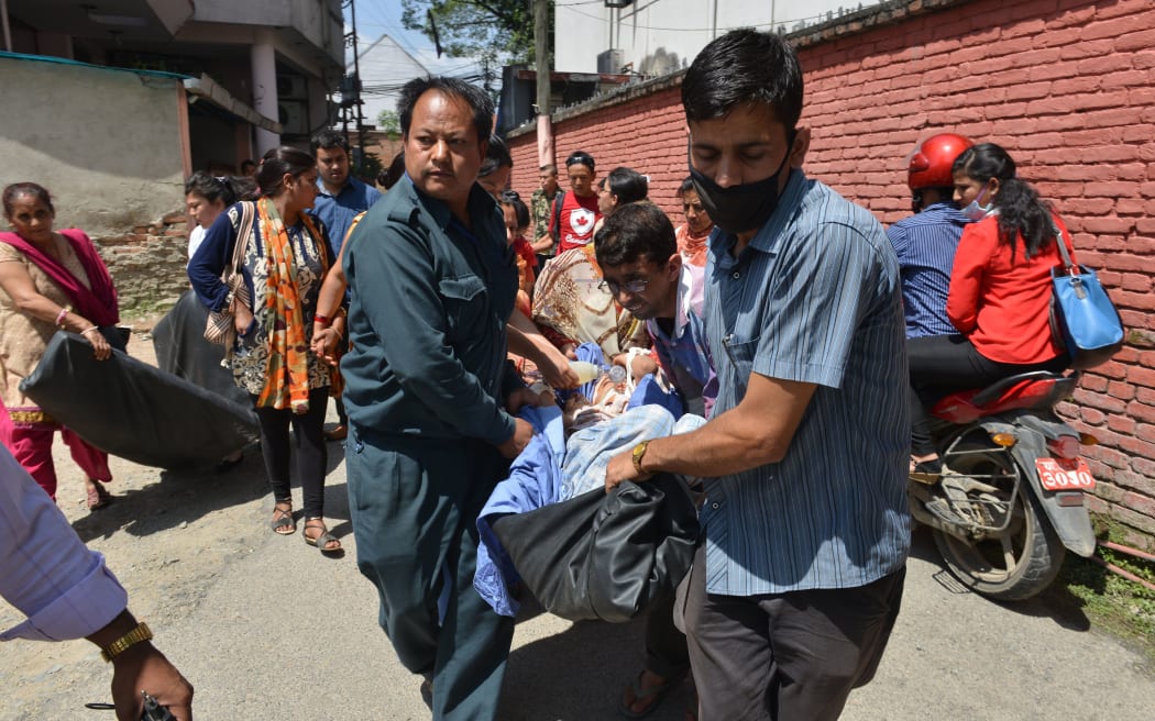 Nepalese patients are carried out of a hospital building following the 7.4 magnitude earthquake.