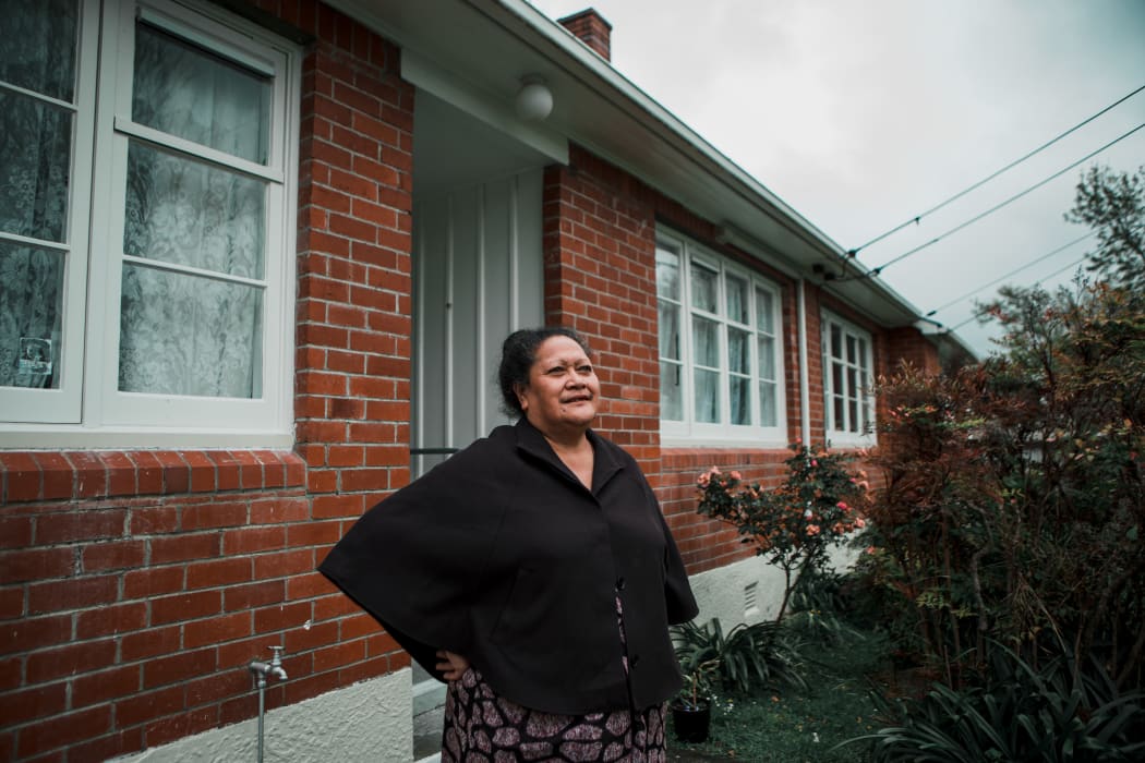 Lina stands outside her home in Naenae