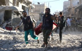 Volunteers carry out the wounded after government forces bombard rebel-held Heluk district in Aleppo.