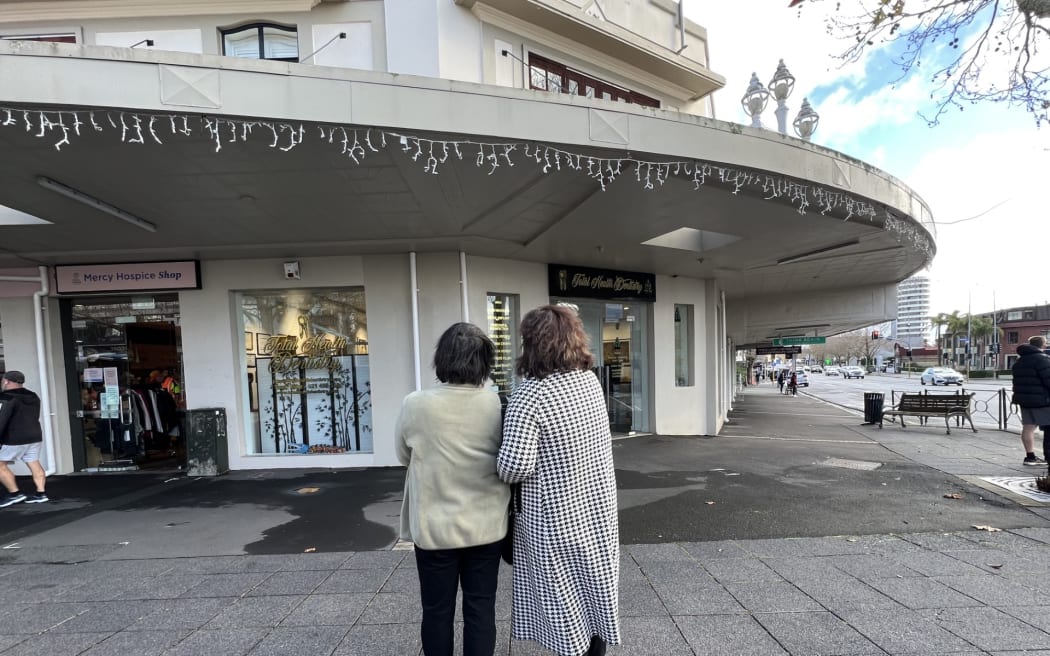 Rao Jing stands with the wife of another patient outside Total Health Dentistry in Auckland's Ponsonby neighbourhood on Monday.