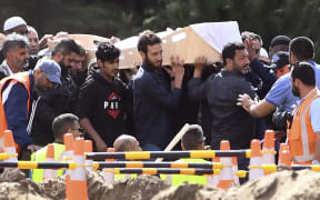 Mourners carry the first coffins of victims killed in the mosque attacks during a funeral at the Memorial Park cemetery in Christchurch