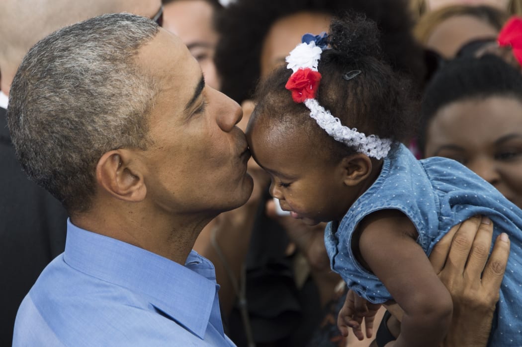 US President Barack Obama holds up a baby after speaking in Kissimmee, Florida, November 6, 2016 as he campaigns for Democratic presidential nominee Hillary Clinton during a Hillary for America campaign event.