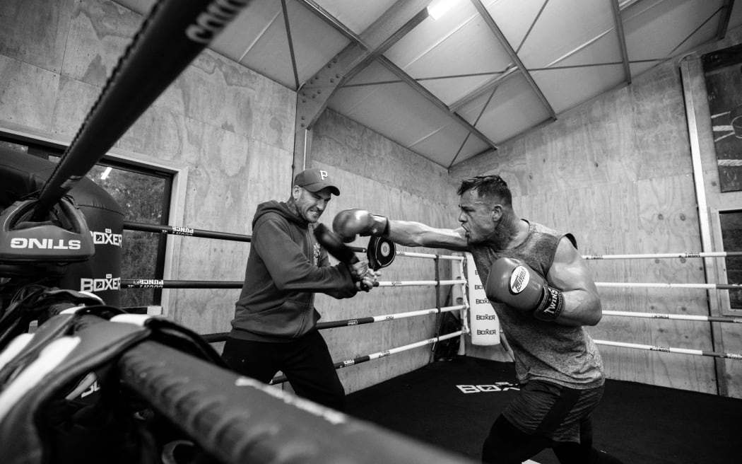 Isaac Peach trains with a boxer at his gym.