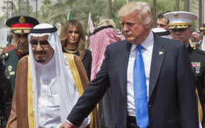 US President Donald Trump holding the hand of Saudi Arabia's King Salman bin Abdulaziz al-Saud (L), as First Lady Melania Trump  looks on, as they arrive for a welcoming ceremony at the Saudi Royal Court in Riyadh on 20 May, 2017.