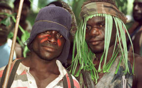 Guerillas of the Bougainville Revolutionary Army (BRA), some still wearing camouflage, watch the signing ceremony of the Bougainville Ceasefire Agreement at Arawa on Bougainville 30 April