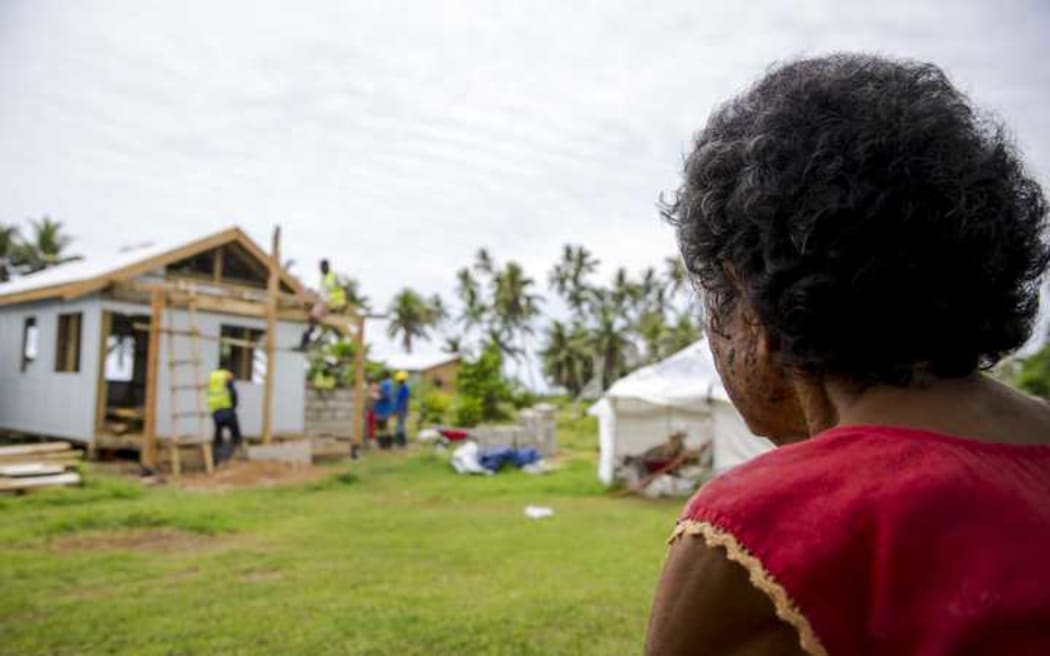 Makarita from Nukubalavu Village watches as her house is rebuilt after Cyclone Winston