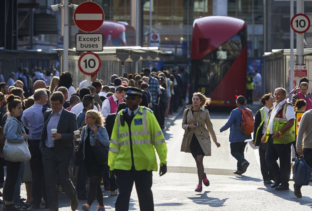 Early morning commuters form queues to board buses at Victoria station during a tube strike in London.