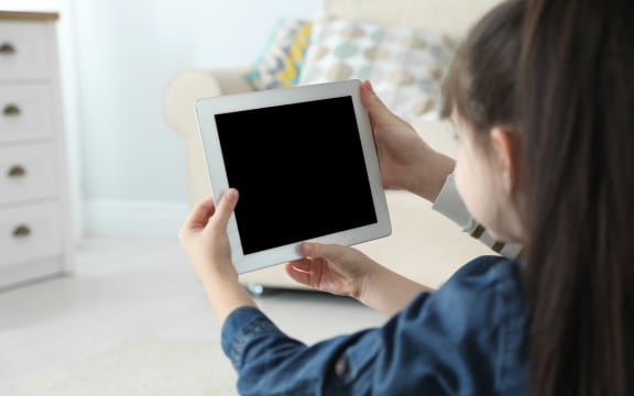 Mother and her daughter using video chat on tablet at home. Space for text