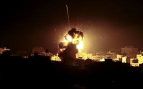A ball of fire rises above a building believed to house the offices of Hamas political chief in Gaza, Ismail Haniyeh, during strikes carried out by the Israeli army in retaliation for a rocket that damaged a house, injuring seven people.