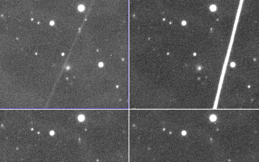 彗星 C/2014 UN271 (Bernardinelli-Bernstein) の白黒画像と、画像内の衛星によって残されたいくつかの光の筋