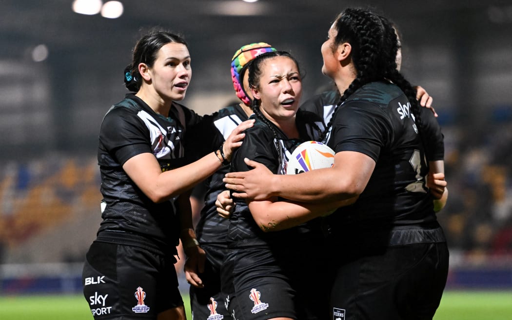Raecene McGregor of New Zealand celebrates with teammates after scoring a try against Cook Islands.