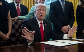 US President Donald Trump signs an executive order with small business leaders in the Oval Office at the White House in Washington DC on January 30