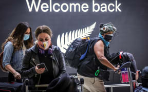 Passengers wearing masks arrive from New Zealand at Sydney International Airport on October 16, 2020.