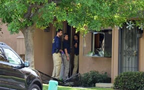 FBI agents investigate at a townhome in Redlands, California, which is linked to the shooting rampage in San Bernardino.