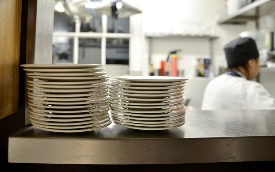 Stack of plates on shelf in commercial kitchen