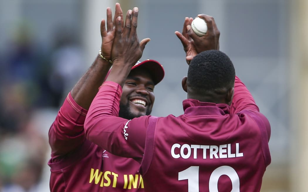 West Indies cricketers Carlos Brathwaite and Sheldon Cottrell celebrate a wicket.