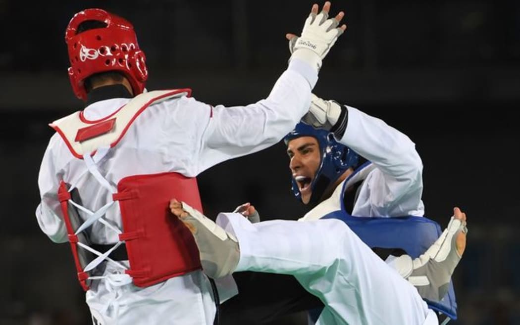 Tonga's Pita Taufatofua lands a blow on Iran's Sajjad Mardani during their men's in his +80kg taekwondo qualifying bout in Rio.