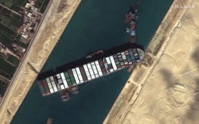 Tug boats and dredgers on March 27, 2021, attempting to free the ship Ever Given, which was lodged sideways and impeding all traffic across Egypt's Suez Canal.