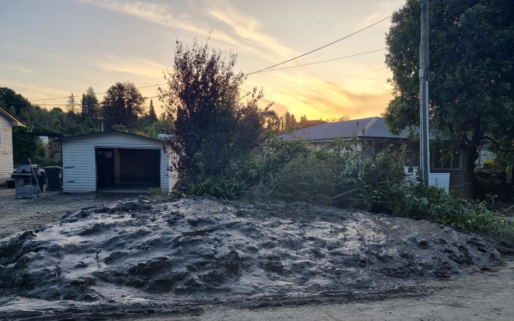 Joll Road, Havelock North 的图片。 该镇基本上没有受到飓风的影响，但有一小部分地区就没那么幸运了。 这条街背靠 Mangarau Stream，被毁坏了。 与邻近街道上修剪整齐的草坪和修剪整齐的树篱形成鲜明对比。